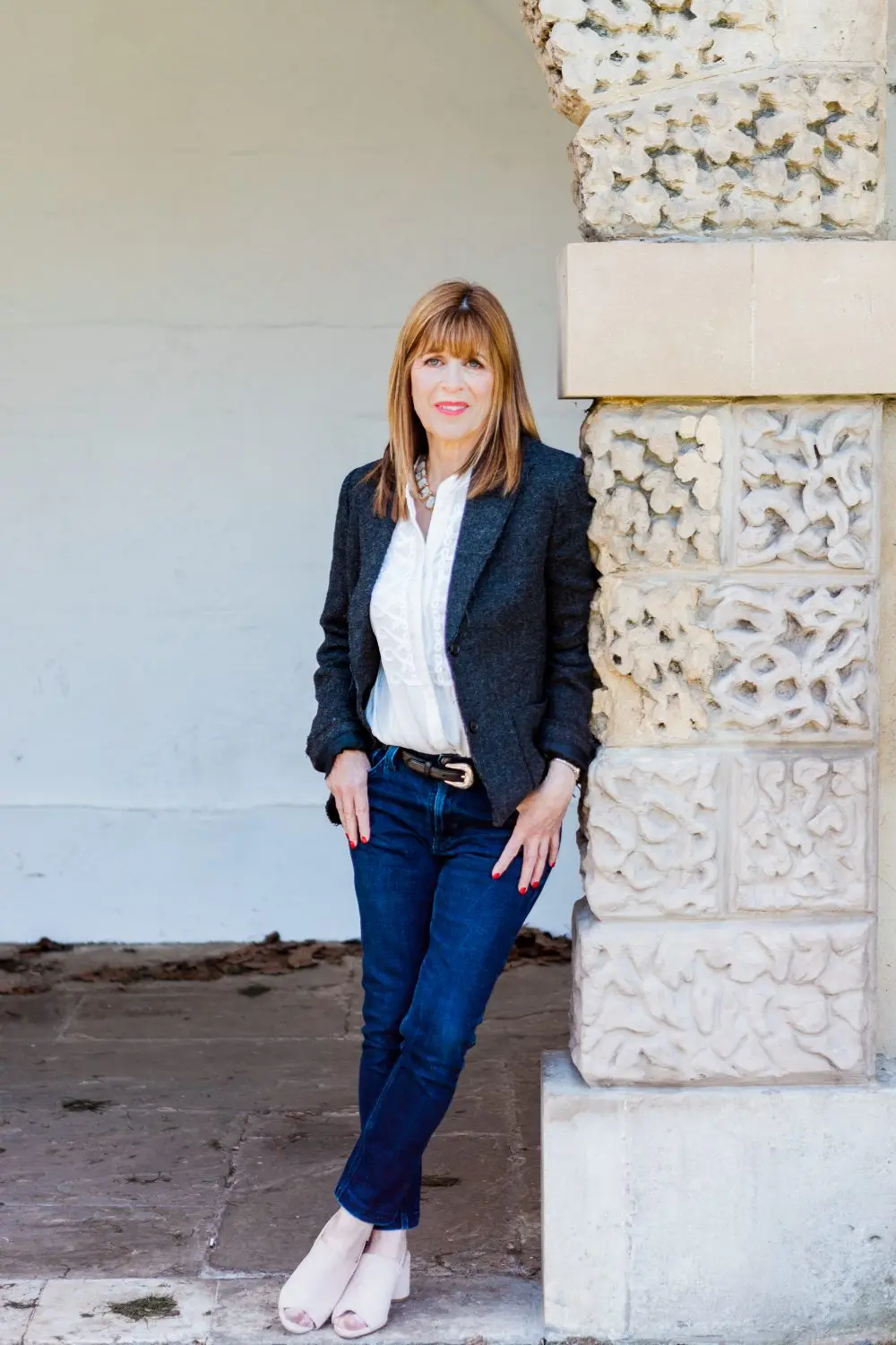 Dr Annie Kaszina standing calmly beside a carved stone pillar